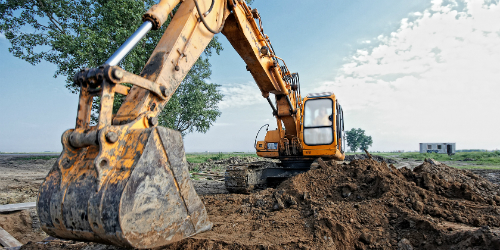 Digger parked on a mound of dirt