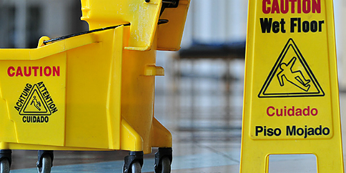 Caution Wet Floor sign next to mop bucket