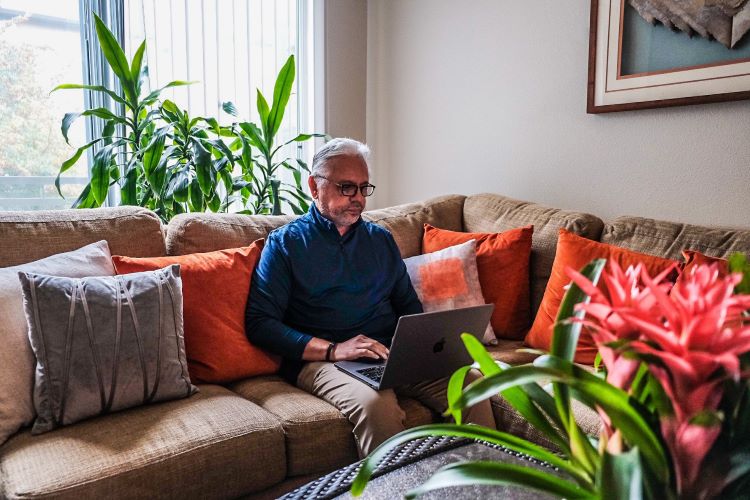 Man sitting on couch using a laptop